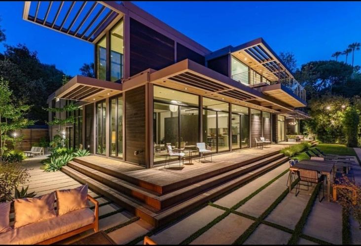 Modern house exterior with large windows and evening lighting