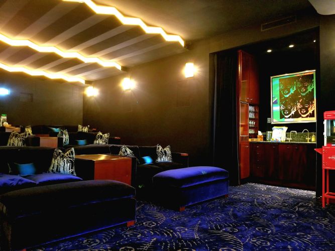 Home theater room with blue seating and warm ceiling lights