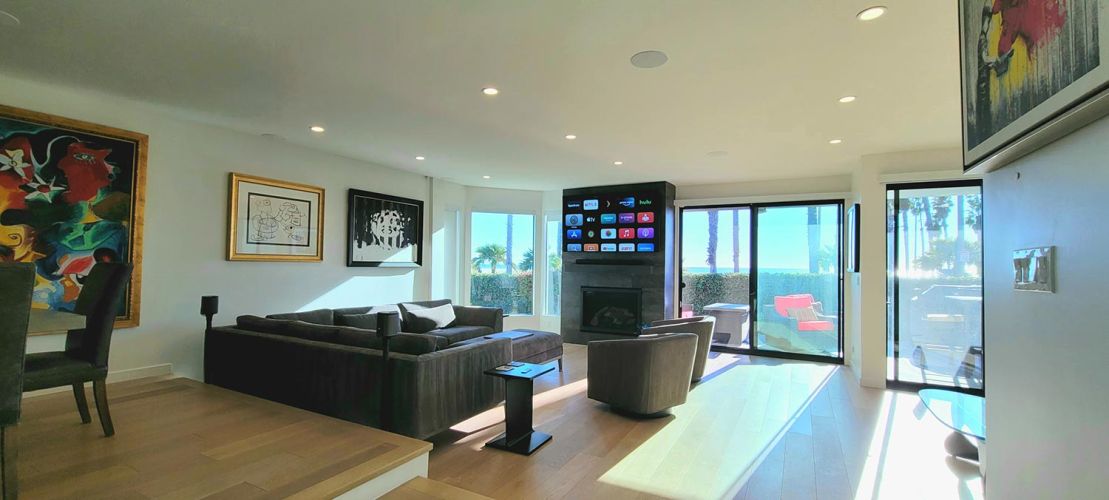 Bright living room with a TV above a fireplace and ocean views