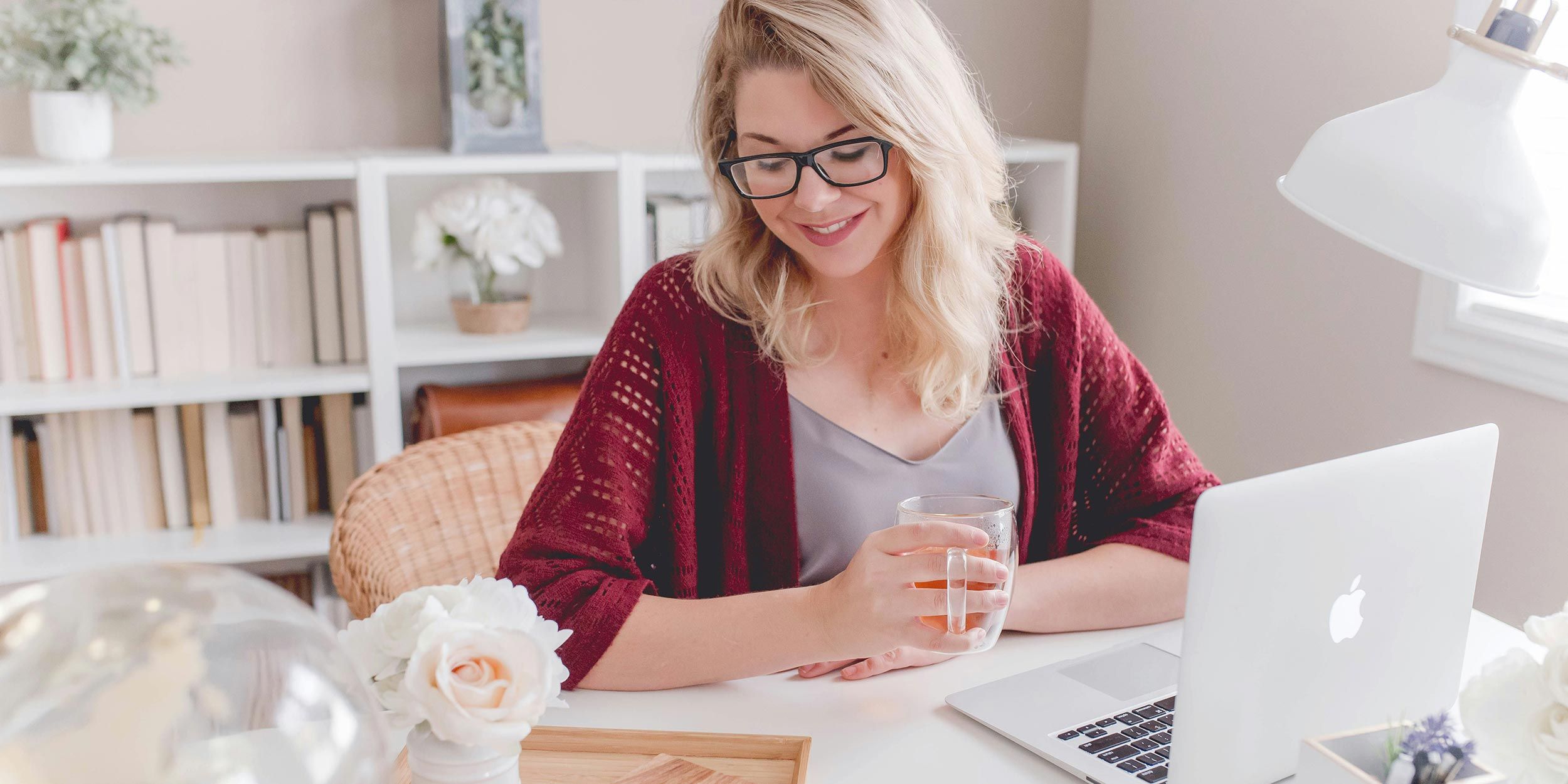 Woman working on a laptop at a bright home office desk