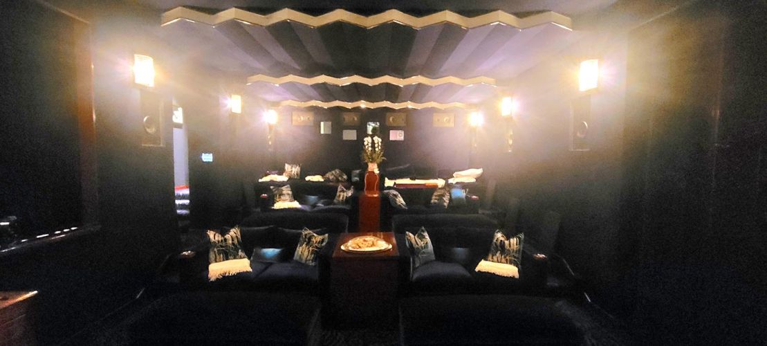 Dim home theater with tiered seating and soft wall lighting
